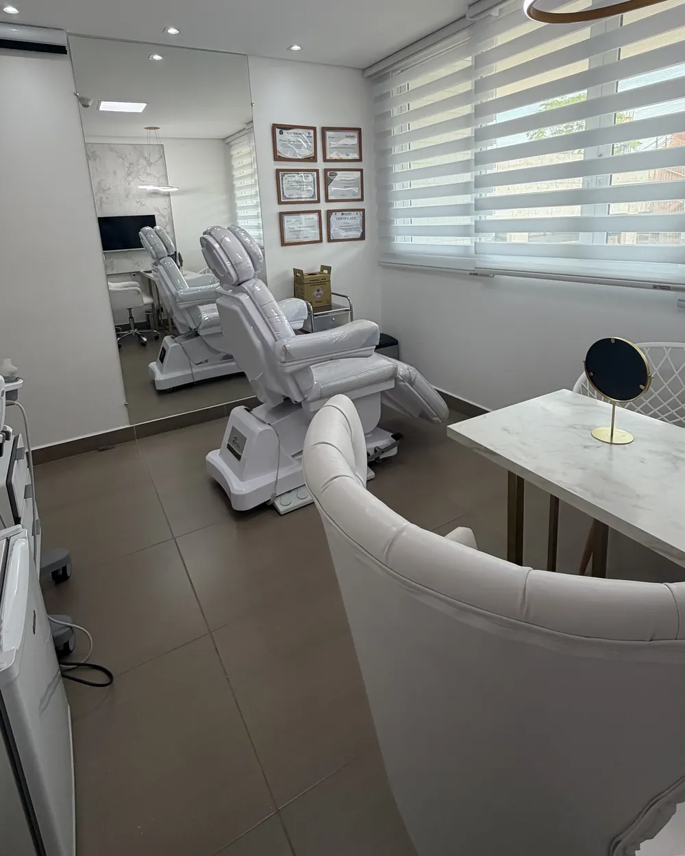 Consultório com cadeira de procedimentos e mesa de avaliação